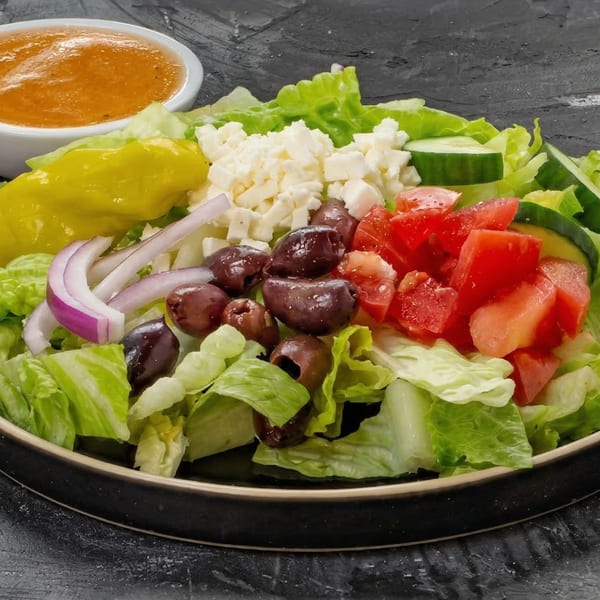 Fresh New York Pizza and Pints salad with lettuce, tomatoes, olives, feta, onions, and dressing.